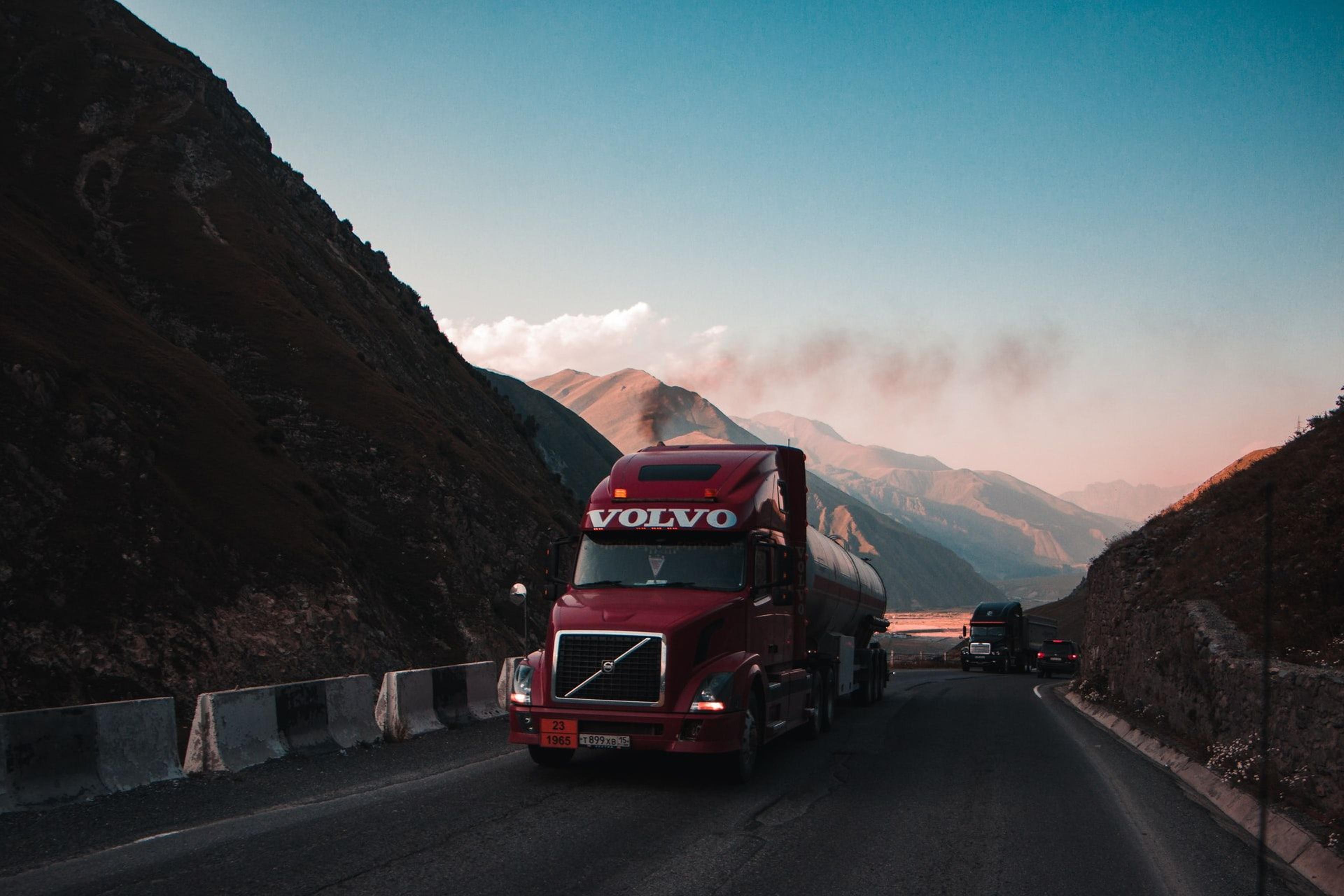 Volvo semi-truck driving down a mountain road