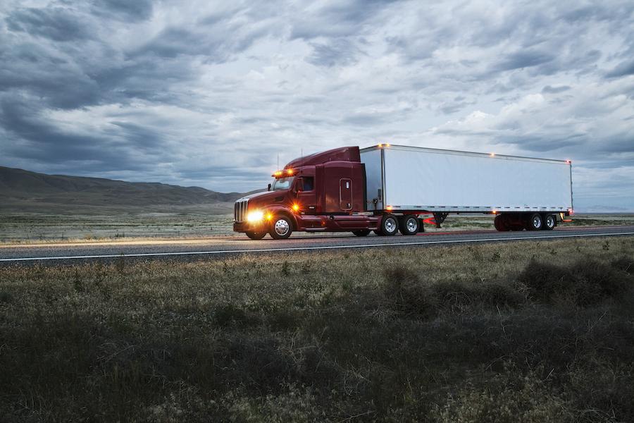 Truck driving on a highway through the grasslands