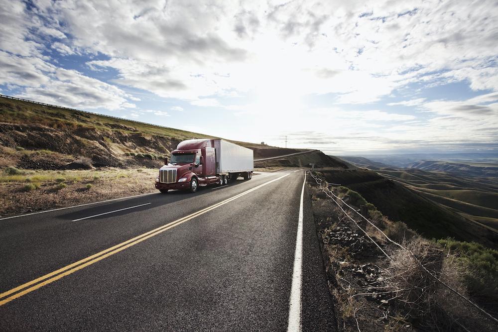 Commercial truck driving through the high desert.