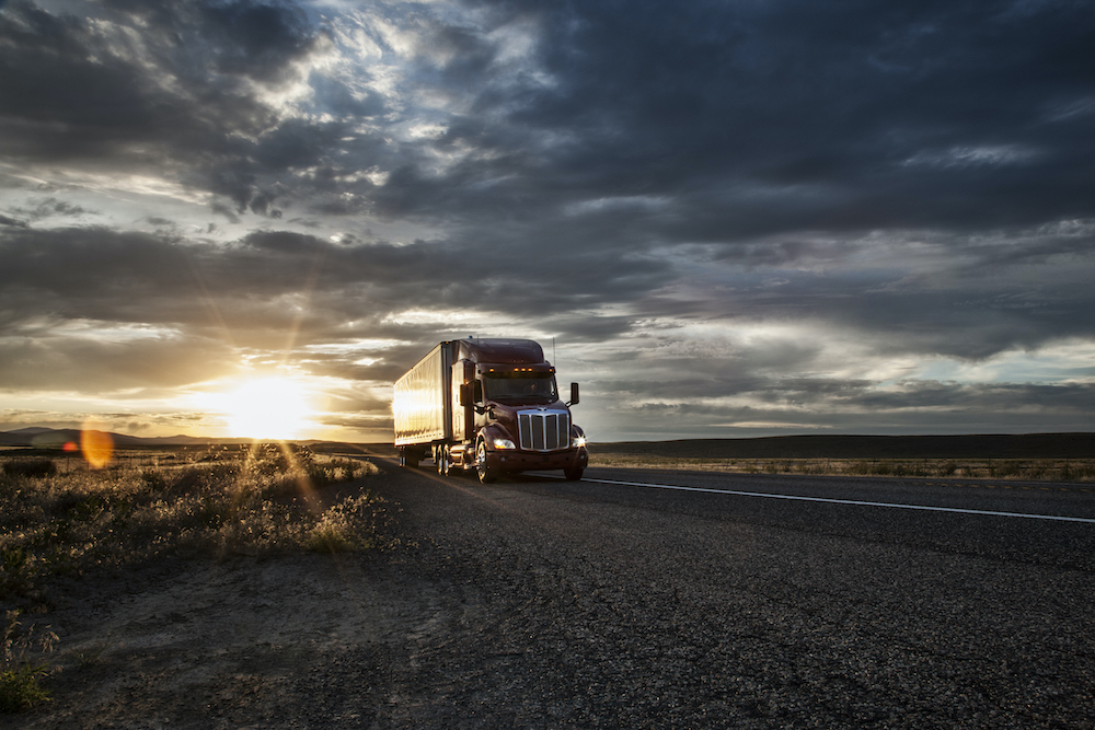 3/4 front view of a commercial truck on the road at sunset in eastern Washington, USA