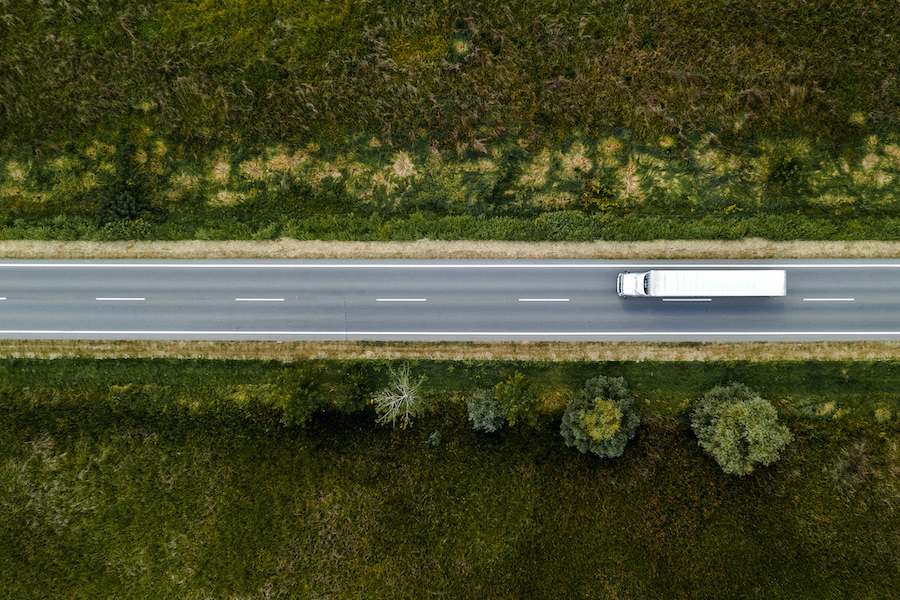 Large freight transporter semi-truck on the road, aerial view top down from drone pov